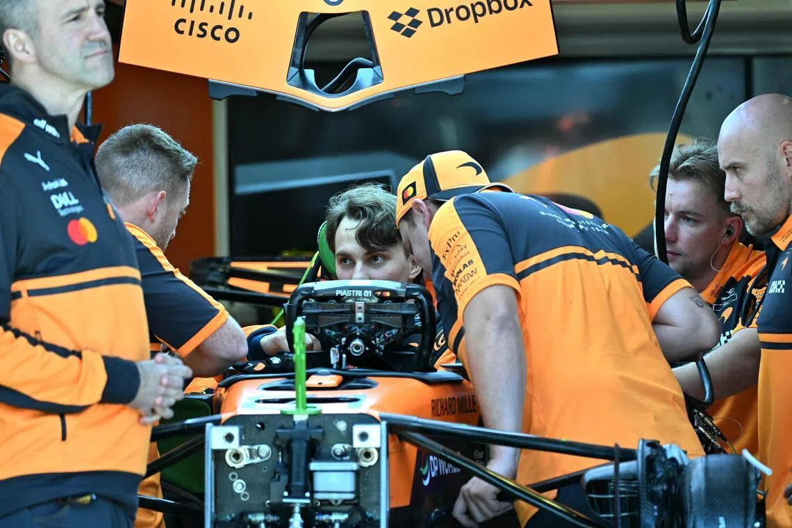 McLaren's Australian driver Oscar Piastri inspects his car with team mechanics in the garage ahead of the Australian Grand Prix at Melbourne’s Albert Park on March 5.