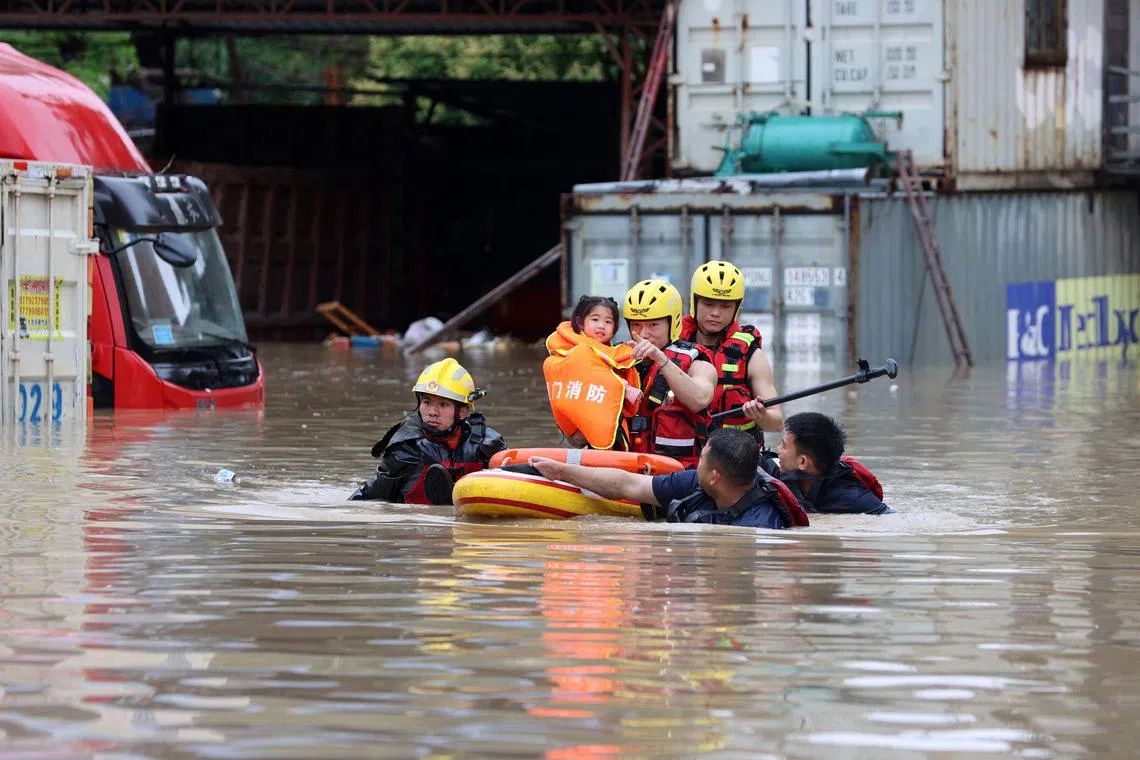 Rescuers evacuating residents after heavy rains hit Xiamen, in China's eastern Fujian province.
