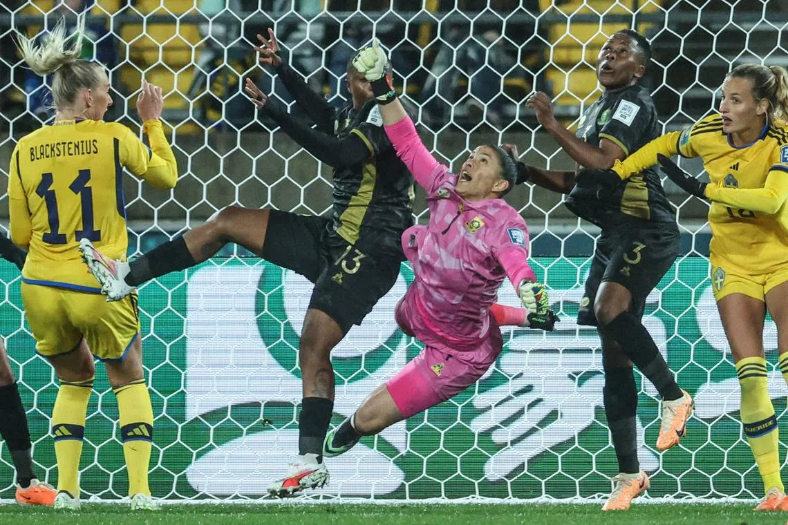 South Africa's goalkeeper Kaylin Swart (C) jumps to save the ball during the Australia and New Zealand 2023 Women's World Cup Group G football match between Sweden and South Africa at Wellington Stadium, also known as Sky Stadium, in Wellington on July 23.
