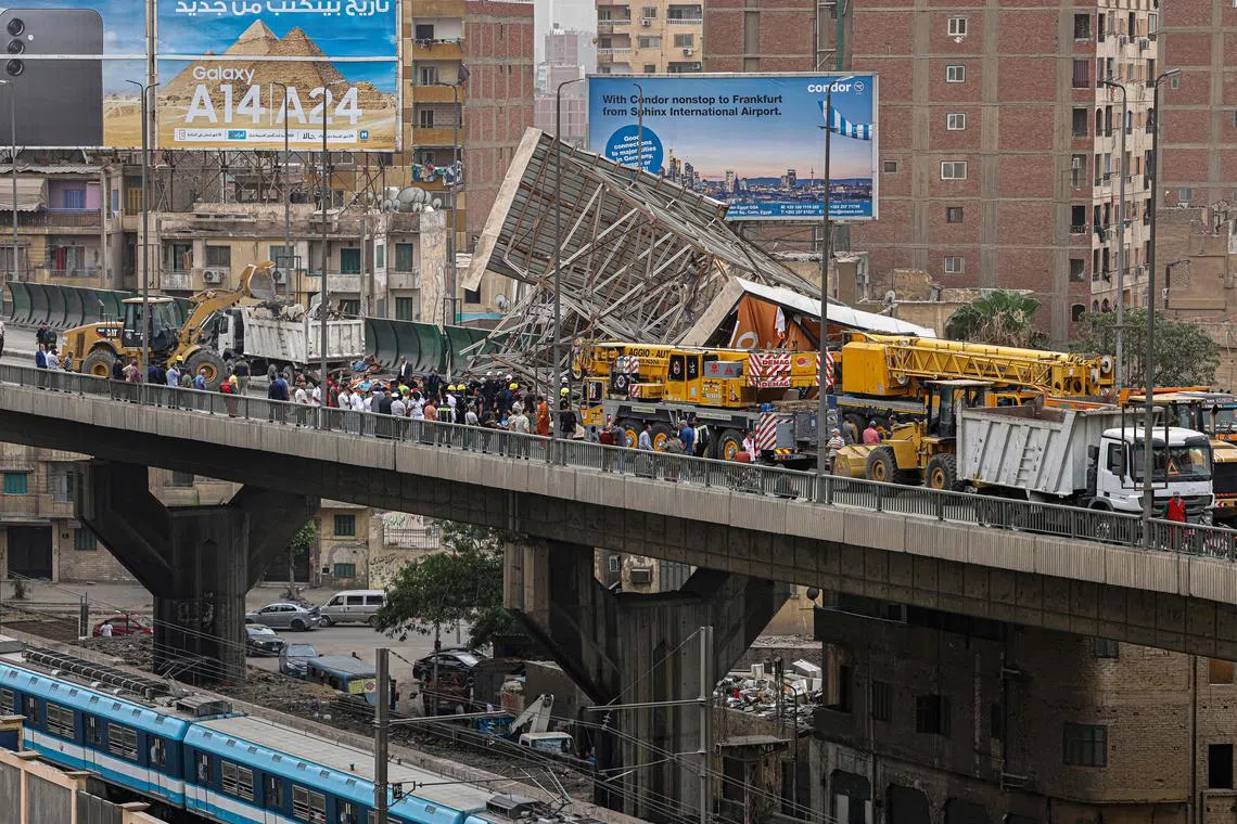 Police and civil defence gather as a collapsed billboard is removed from the overpass bridge in the Ghamra neighbourhood in central Cairo on June 1, 2023.