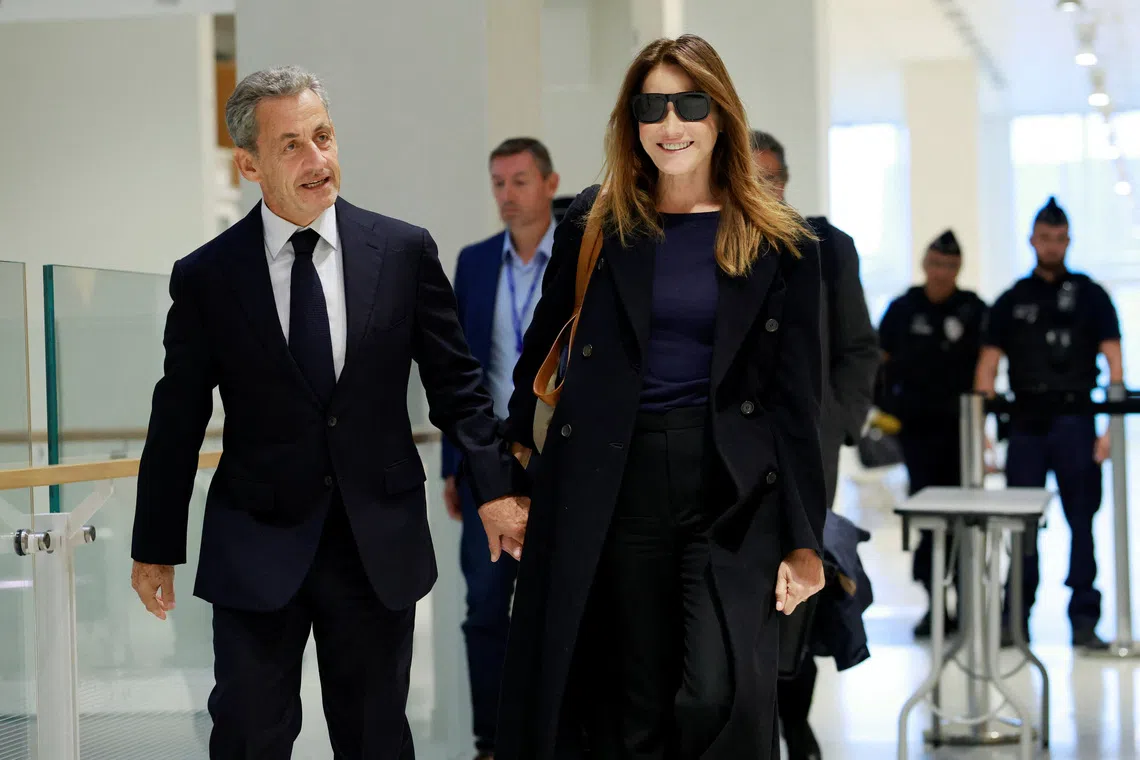Former French President Nicolas Sarkozy arrives with his wife Carla Bruni-Sarkozy for the verdict in his trial with other defendants on charges of corruption and illegal financing of an election campaign related to alleged Libyan funding of his successful 2007 presidential bid, at the courthouse in Paris, France, September 25, 2025. REUTERS/Stephanie Lecocq