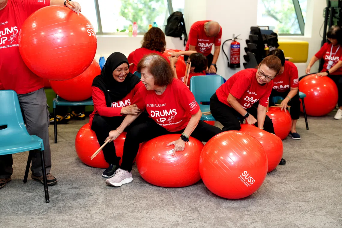 Seniors from different active ageing centres preparing for a cardio drumming performance at an SG60 NDP celebration event.