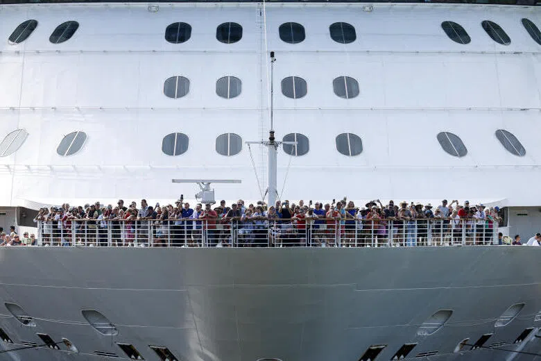 Tourists standing on deck as the cruise ship Brilliance of the Seas enters the Miraflores locks of the Panama Canal.