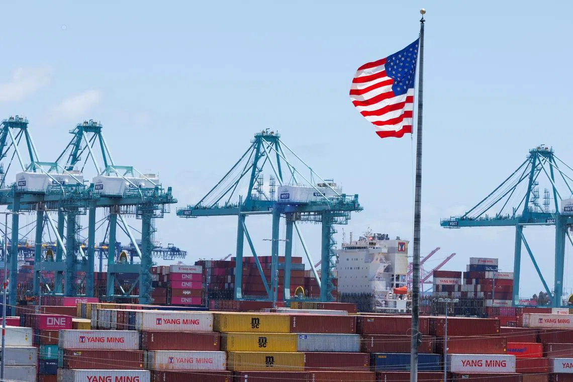 An American flag flutters over a ship and shipping containers at the Port of Los Angeles, in San Pedro California, U.S., May 13, 2025. REUTERS/Mike Blake