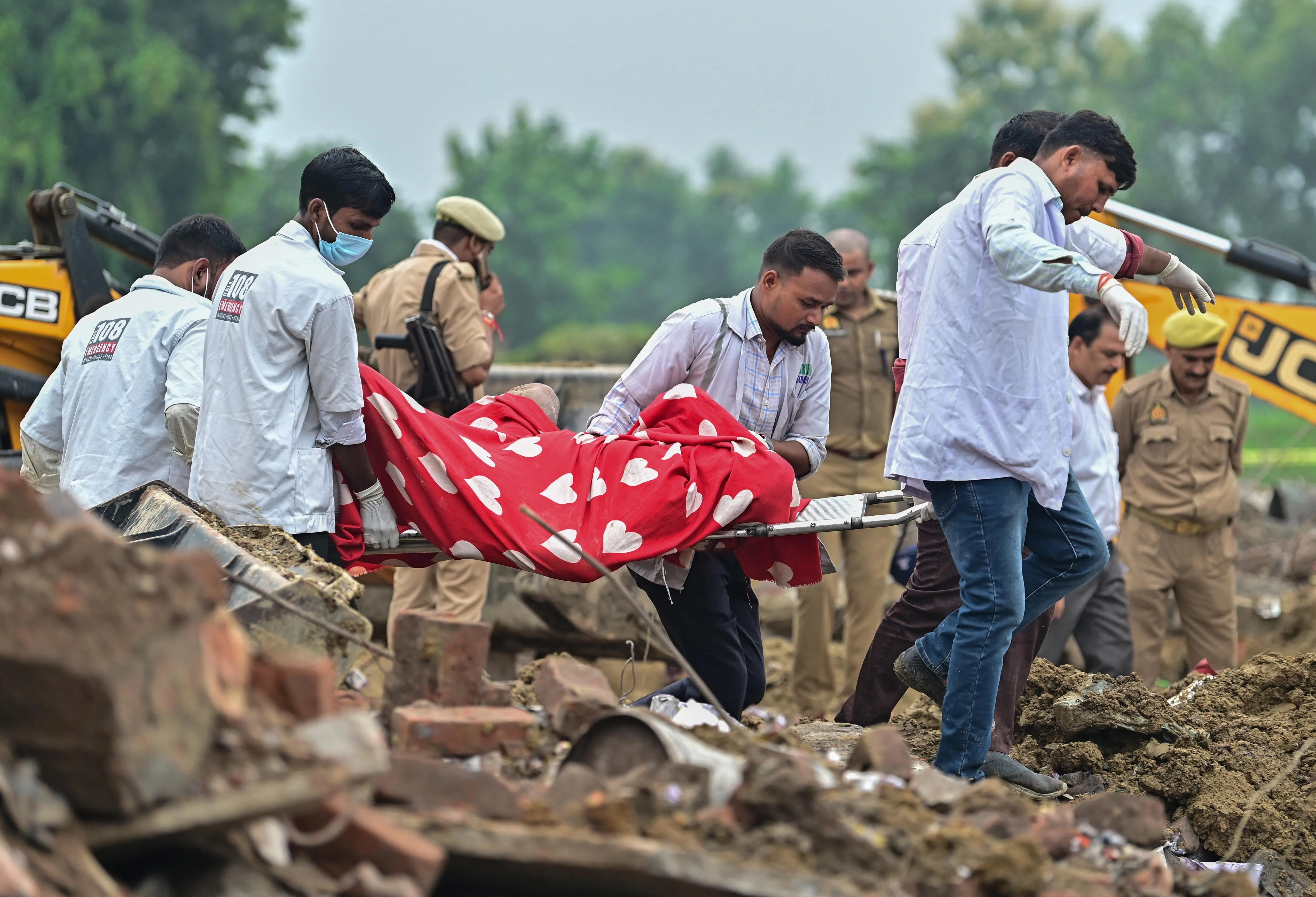 epa13202390 Indian health workers carry the mortal remains of a victim as they perform rescue work at a site after an explosion in a firecracker factory in Pipri, Uttar Pradesh state, India, 31 August 2026. The explosion in the  firecracker factory killed more than five people and several injured, according to official sources. The explosion also damaged the nearby houses.  EPA/Prabhat Kumar Verma