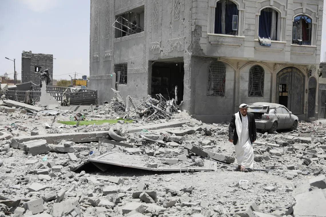 A man walks on the rubble of a building destroyed by U.S. air strikes in Sanaa, Yemen April 27, 2025. REUTERS/Khaled Abdullah