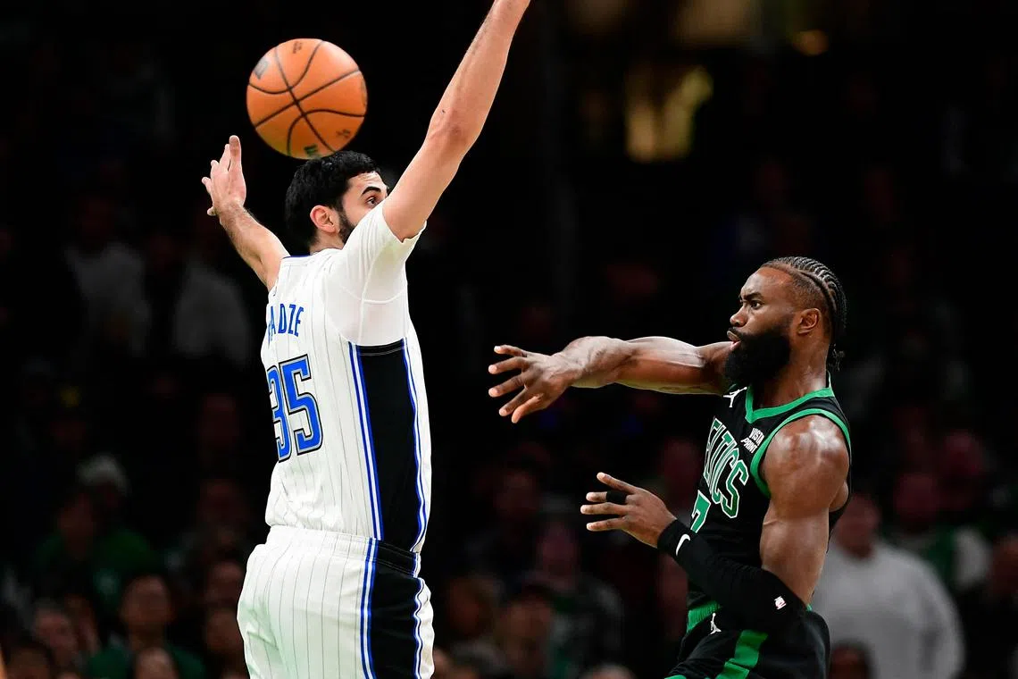Boston Celtics guard Jaylen Brown passing the ball through the defence of Orlando Magic centre Goga Bitadze during the first half at TD Garden on Dec 17.
