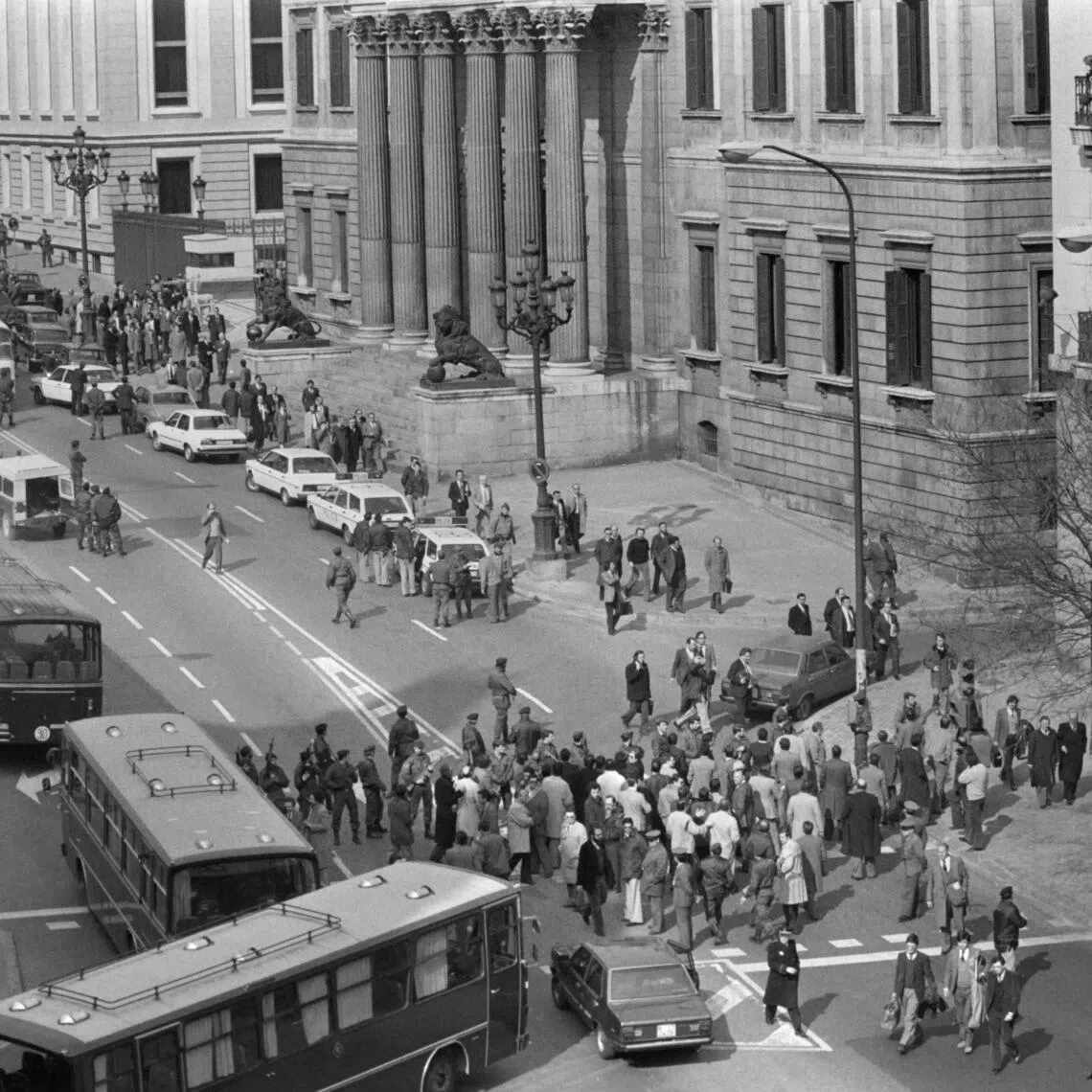 Journalists, policemen and civil guards wait for the release of Parliament deputies, outside the Parliament building in Madrid, on Feb 24, 1981 after the attempted coup.