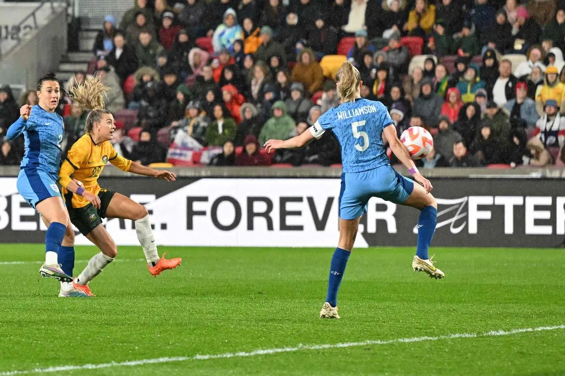 Australia defender Charlotte Grant scoring the team's second goal past England captain midfielder Leah Williamson in their International football friendly in Brentford, west London on April 11, 2023..