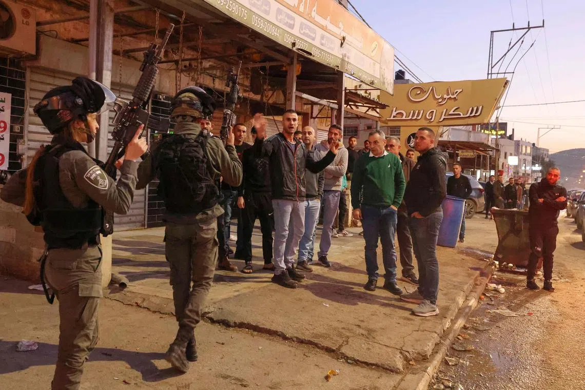Palestinians react against an Israeli search in the occupied West Bank city of Hawara, on Dec 2, 2022.