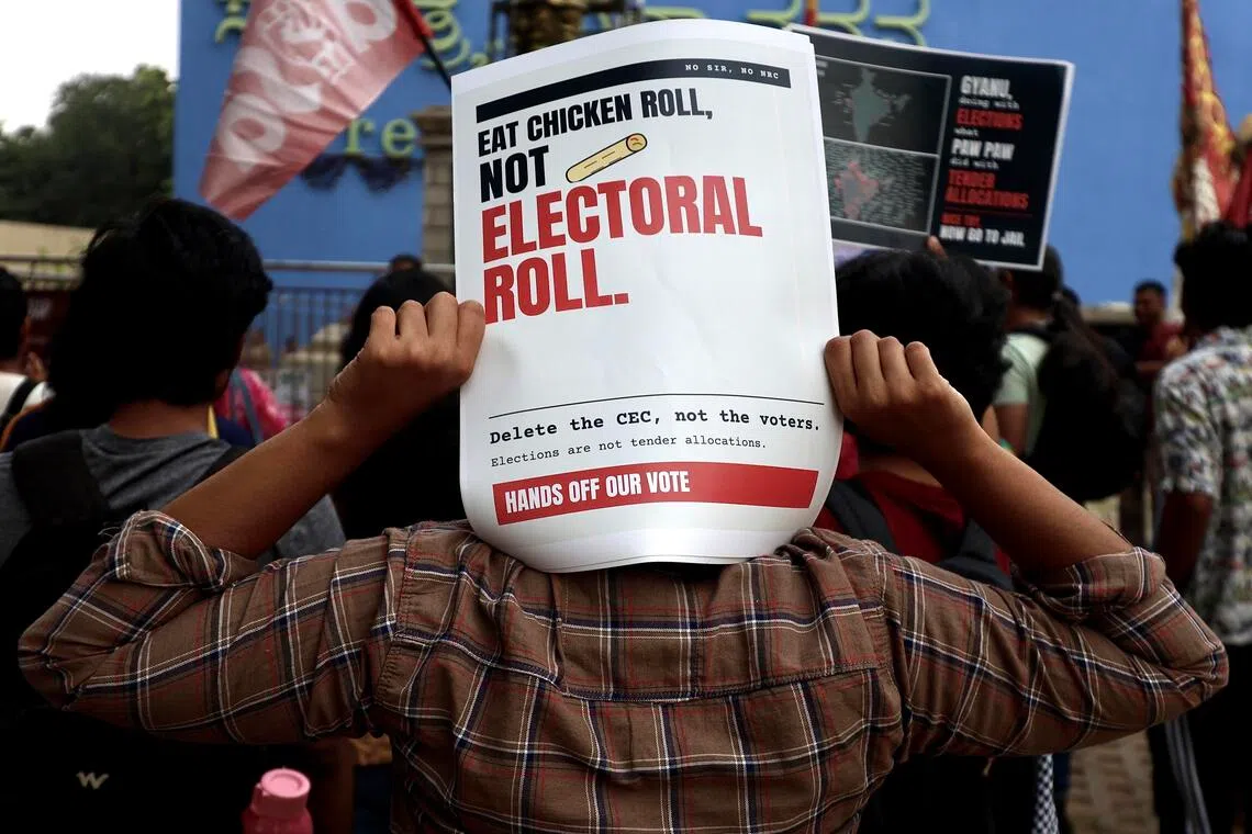 Members of the All India Students’ Association, social activists and members of the Cockroach Janta Party hold placards and shout slogans during a protest against the central government over voter-list revisions.