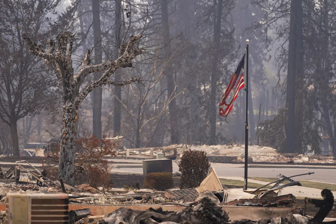 A torn American flag flutters among incinerated neigbourhood in the Old Trails Fire, in Spokane, Washington, U.S., August 3, 2026. REUTERS/David Ryder
