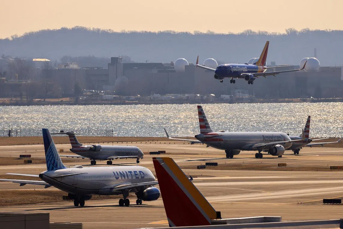 FILE PHOTO: A plane prepares to land as other planes wait their turn in a busy runway at the Ronald Reagan Washington National Airport in Arlington, Virginia, U.S., February 4, 2025.  REUTERS/Eduardo Munoz/File Photo