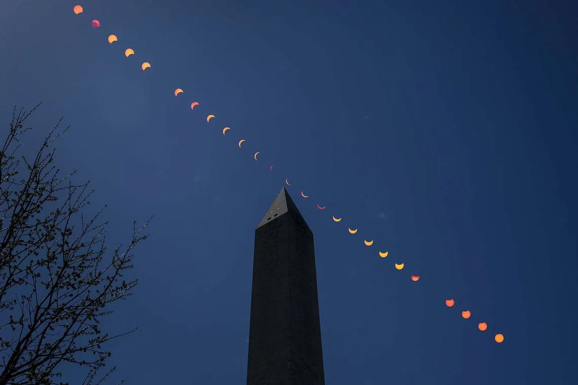 A composite image showing the progression of a partial solar eclipse over the Washington Monument, in Washington, DC on April 8, 2024. 