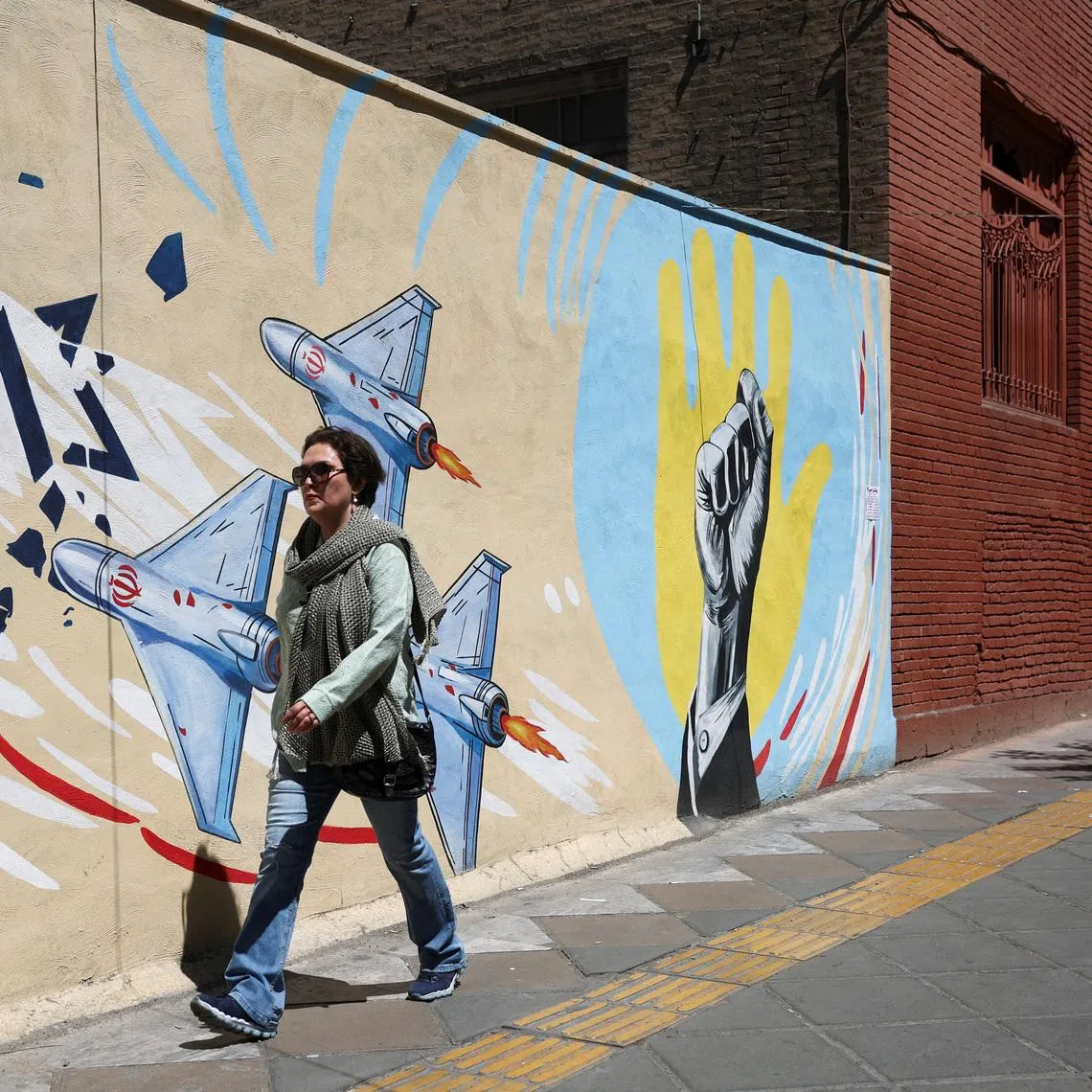 An Iranian woman walks next to an anti-Israeli mural on a street in Tehran, Iran, May 26, 2026. Majid Asgaripour/WANA (West Asia News Agency) via REUTERS