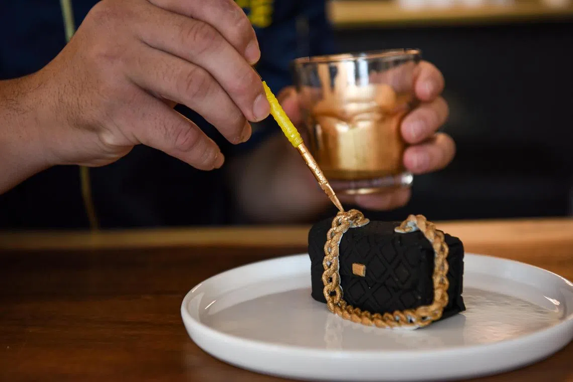 The finishing touches of gold are hand painted on Cotelato's handbag cake which has a brownie filling.