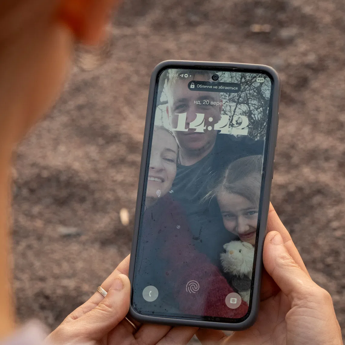 Alina, 32, wife of Ukrainian serviceman Yevheniy Borysenko, looks at a selfie showing herself, her husband and their daughter Snizhana together, amid Russia's attack on Ukraine, in the town of Boryspil, in Kyiv region, Ukraine September 20, 2026. REUTERS/Vladyslav Smilianets
