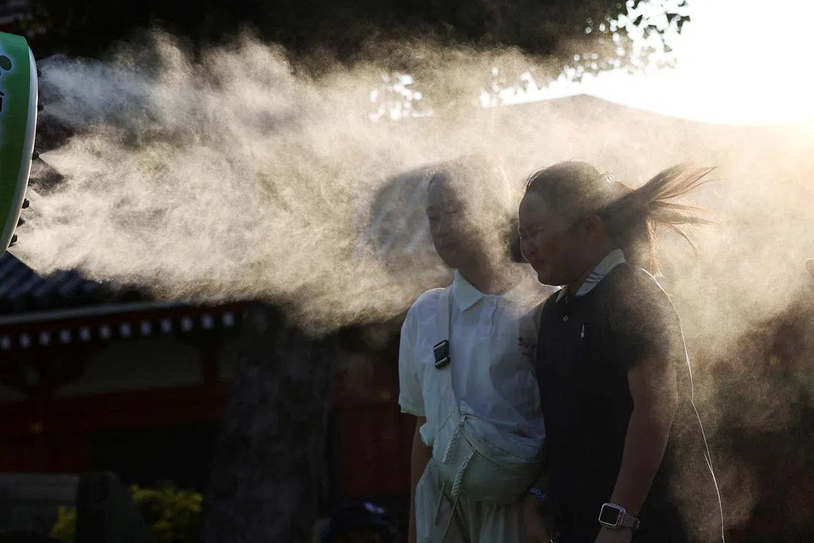 Visitors taking a break next to a cooling mist at Sensoji temple, a popular sightseeing spot, as the Japanese government issued a heatstroke alert in Tokyo and other prefectures due to a heatwave, in Tokyo, Japan Aug 5, 2025. 