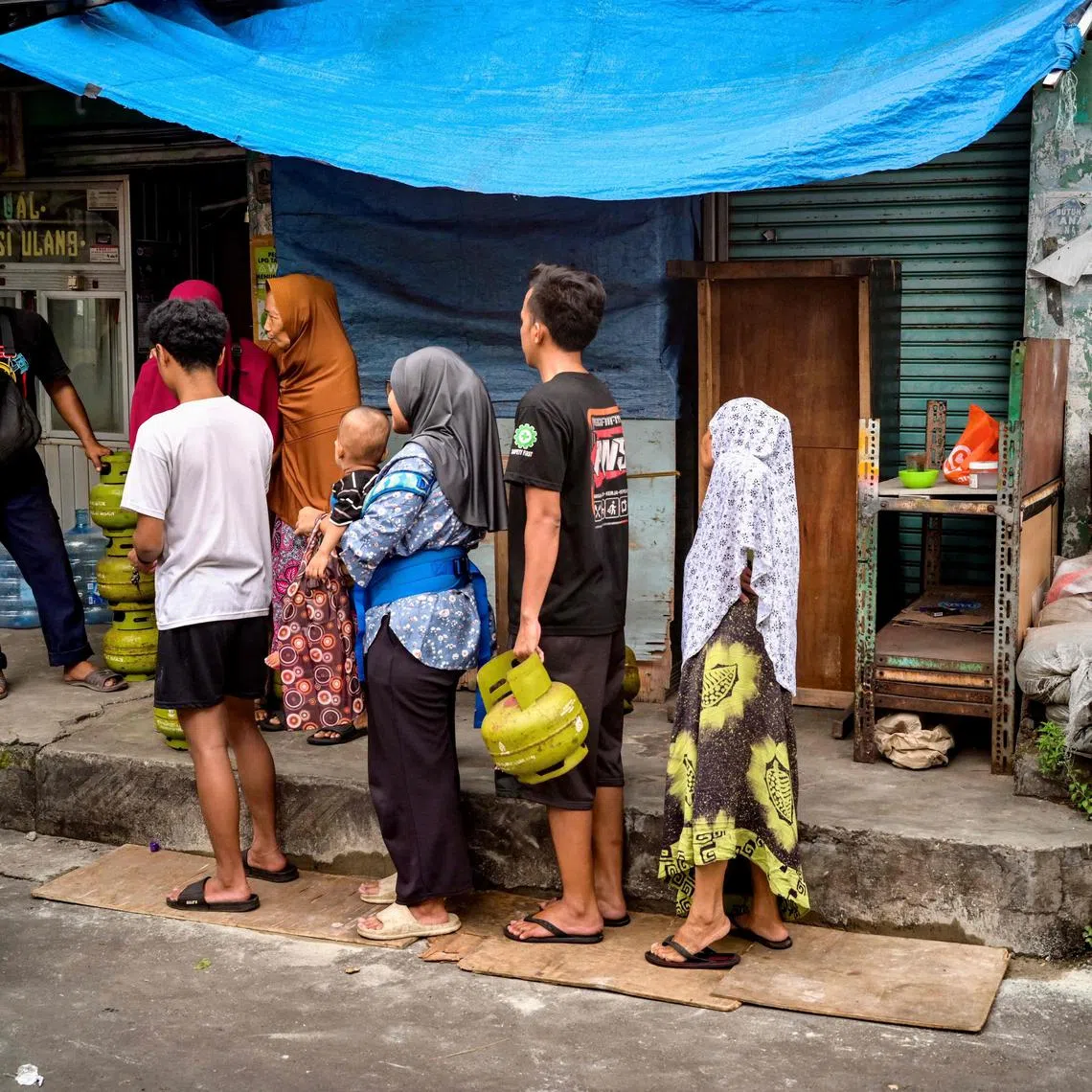 People line up at a store selling cooking gas in Jakarta on February 5, 2025. (Photo by BAY ISMOYO / AFP)