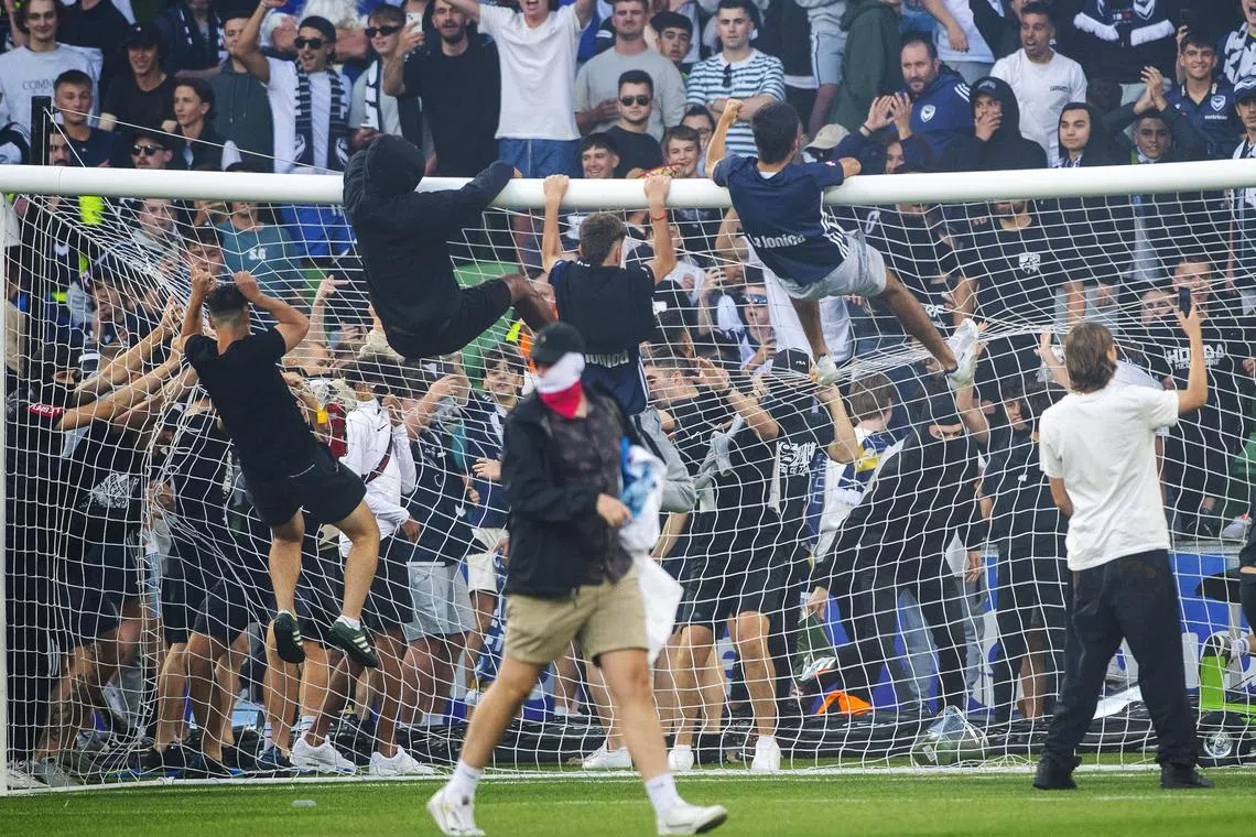 epa10369811 Melbourne Victory fans invade the pitch during the Australian A-League men's soccer match between Melbourne City and the Melbourne Victory at AAMI Park in Melbourne, Australia, 17 December 2022. The match was abandoned after fans attacked Melbourne City goalkeeper Tom Glover in a violent pitch invasion.  EPA-EFE/WILL MURRAY AUSTRALIA AND NEW ZEALAND OUT