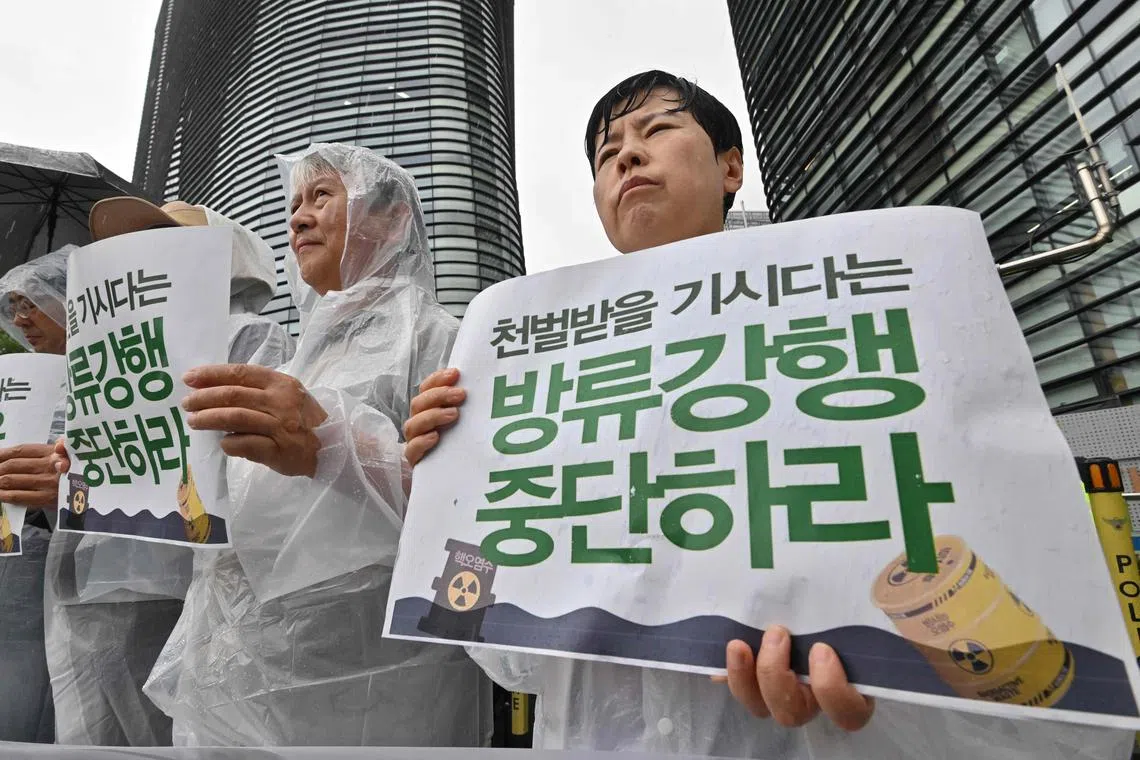 South Korean protesters hold signs reading "Stop the discharge!" during a rally near the Japanese embassy in Seoul on Aug 23, 2023.