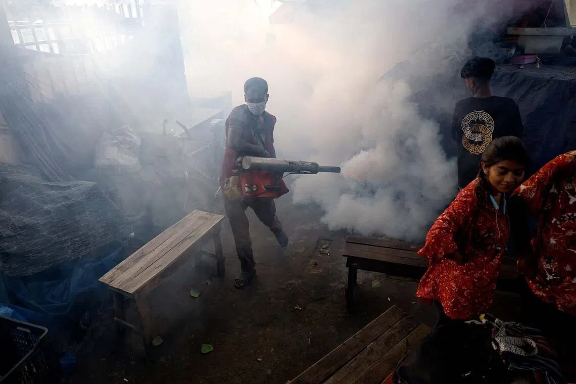 A man fumigating premises as a preventive measure against diseases spread by mosquitoes, in Dhaka, Bangladesh, June 1.