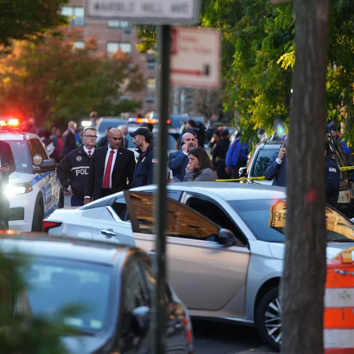 Members of law enforcement gather near a vehicle at the scene of a shooting reportedly involving ICE agents in the Bronx borough of New York City, on Oct 8.