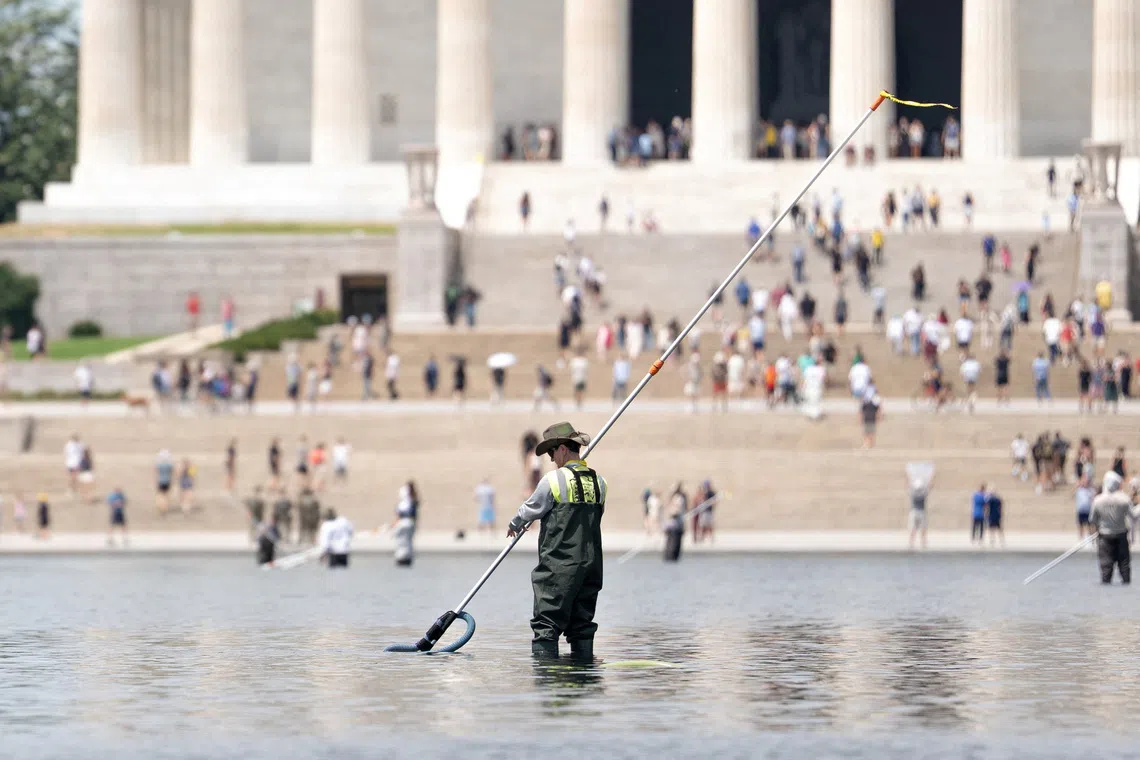 FILE PHOTO: A worker vacuums algae from the Lincoln Memorial Reflecting Pool, after recent renovations following a directive from U.S. President Donald Trump to paint it blue ahead of the 250th anniversary of U.S. Independence, in Washington, D.C., U.S., June 21, 2026. REUTERS/Aaron Schwartz/File Photo