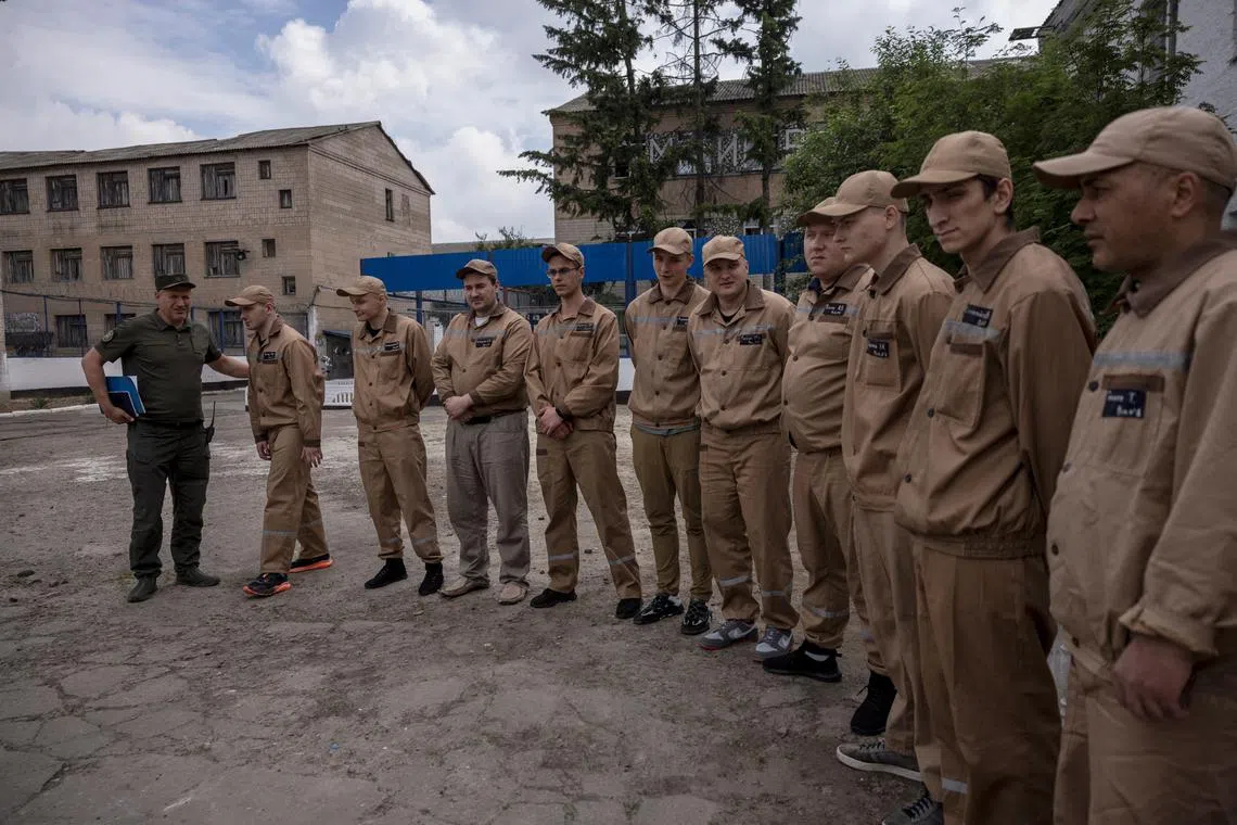 Inmates who agreed to talk to journalists about a government offer to recruit some convicts for the military, line up in the yard of a prison colony in the Kyiv region, Ukraine, May 30, 2024.  REUTERS/Thomas Peter