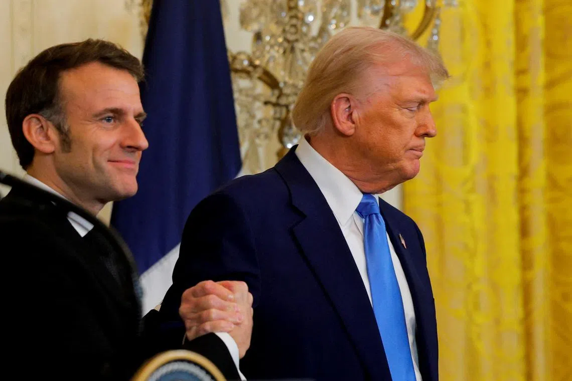 U.S. President Donald Trump and French President Emmanuel Macron react, as they shake hands, during a press conference at the White House in Washington, D.C., U.S., February 24, 2025. REUTERS/Brian Snyder
