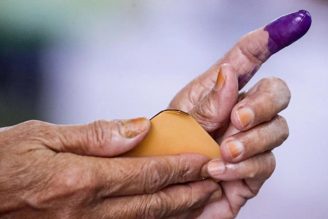 epa10796058 A woman has her finger marked with ink before casting her vote at a polling station during the state election, in Selayang, Malaysia, 12 August 2023. Voting is occuring in six states including Selangor, Kelantan, Penang, Kedah, Negeri Sembilan and Terengganu, with a total of 570 candidates vying for the 245 contested state seats.  EPA-EFE/FAZRY ISMAIL