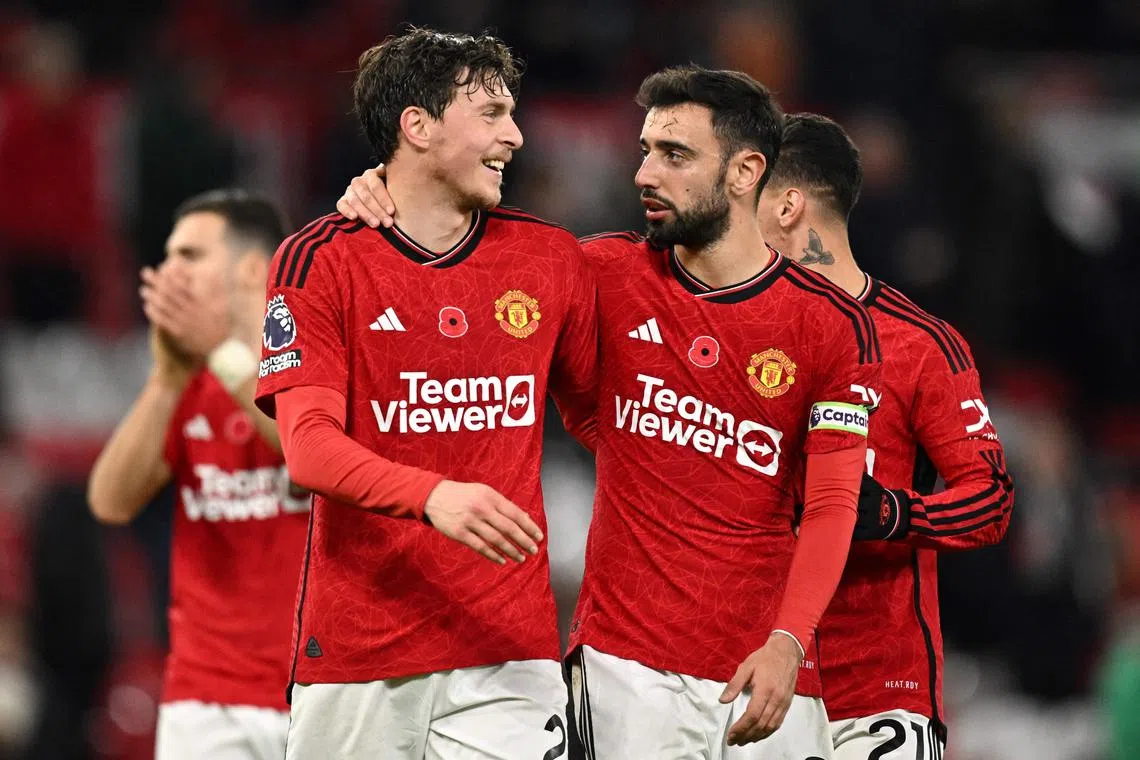 Manchester United's Swedish defender Victor Lindelof (left) is congratulated by teammate Bruno Fernandes at the end of the match.