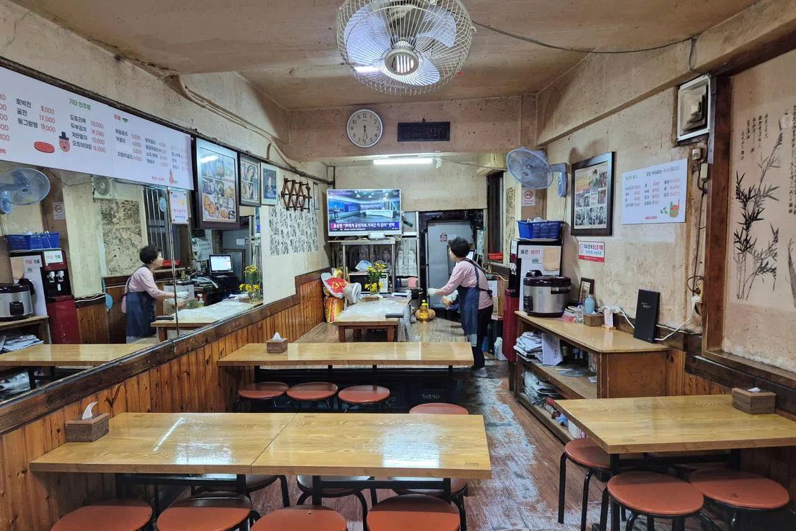 FILE PHOTO: A restaurant owner waits for customers at her empty restaurant in Seoul, South Korea, October 31, 2024.   REUTERS/Cynthia Kim/File Photo