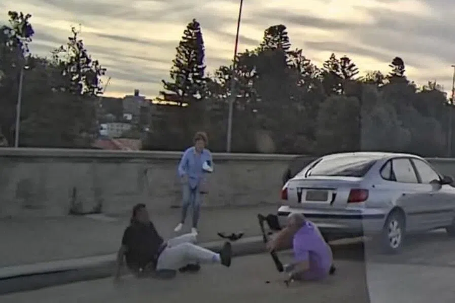 A screenshot from a dashcam clip shows a man falling down after attempting to disarm one of the gunmen behind the Bondi Beach mass shooting.
