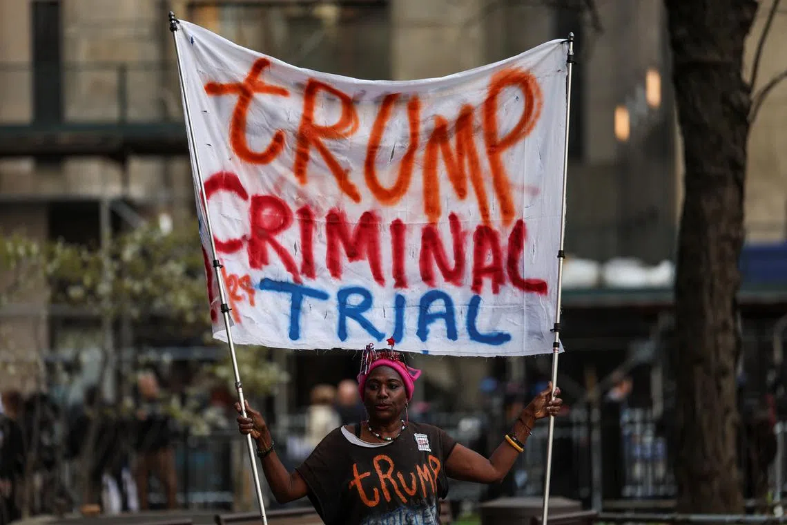 Nadine Seiler, 58, holds a banner against Republican presidential candidate and former U.S. President Donald Trump, outside the courthouse, on the day of his hush money criminal trial, in New York City, U.S., April 15, 2024. REUTERS/Shannon Stapleton