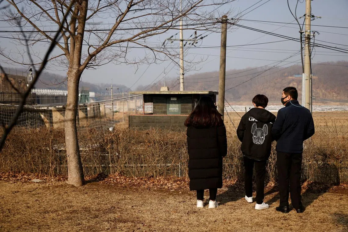 FILE PHOTO: A North Korean defector and his children stand in front of a barbed wire fence near the demilitarised zone separating the two Koreas, in Paju, February 12, 2021, on the occasion of Seolnal, the Korean Lunar New Year's day.   REUTERS/Kim Hong-Ji/File Photo