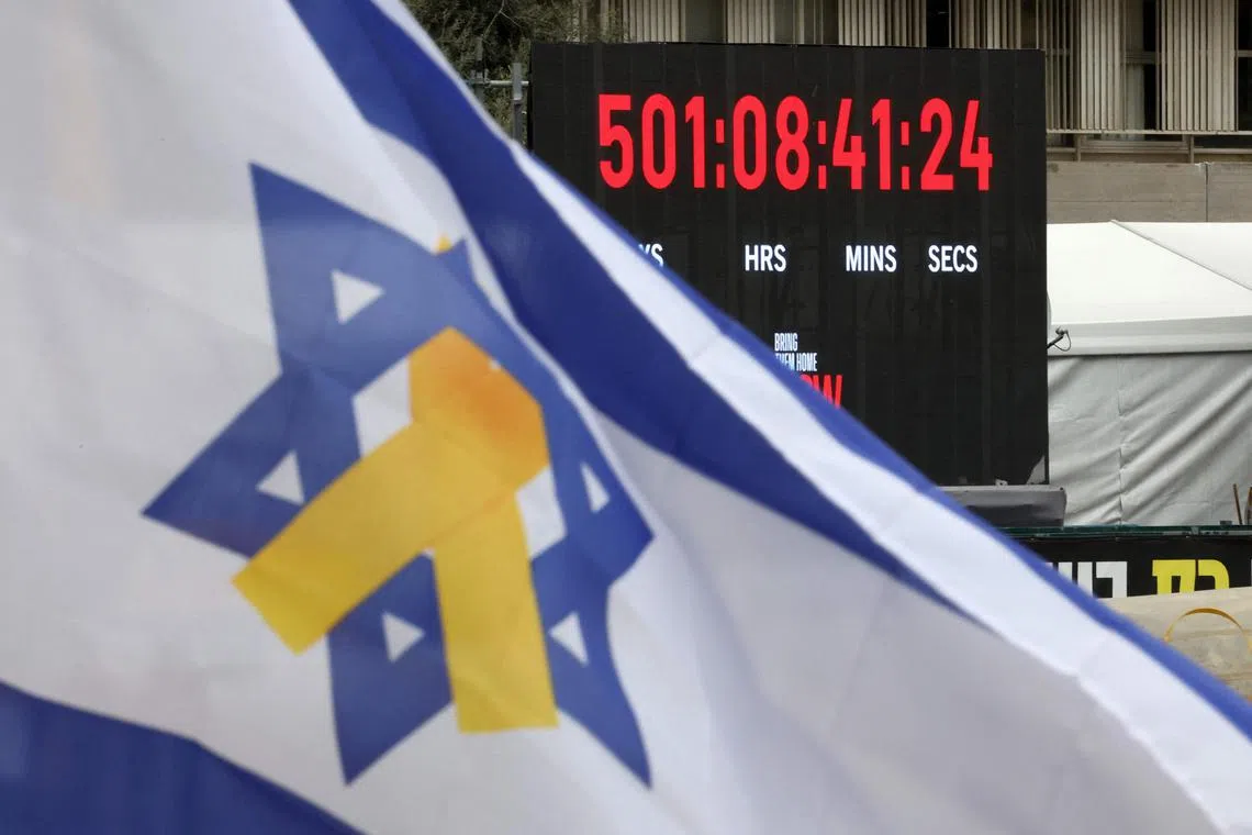 An Israeli flag flying in front of a clock that counts the time Israelis kidnapped by Hamas militants on Oct 7, 2023, have spent in captivity in Gaza.