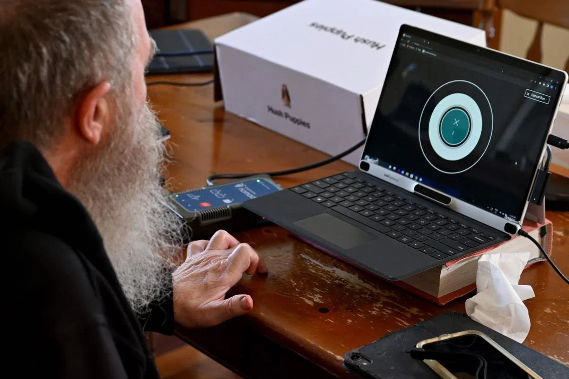 Synchron brain implant recipient Rodney Gorham working on a computer at his home in Melbourne.