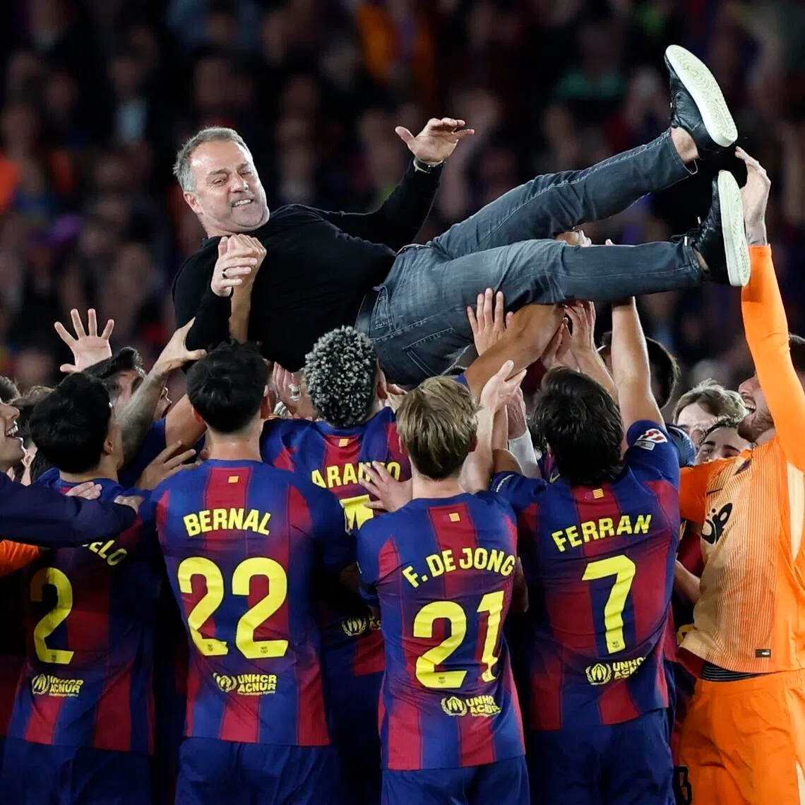 Barcelona's players throwing their coach Hansi Flick in the air in celebration after winning the La Liga title following a 2-0 win over Real Madrid at the Camp Nou on May 10, 2026.
