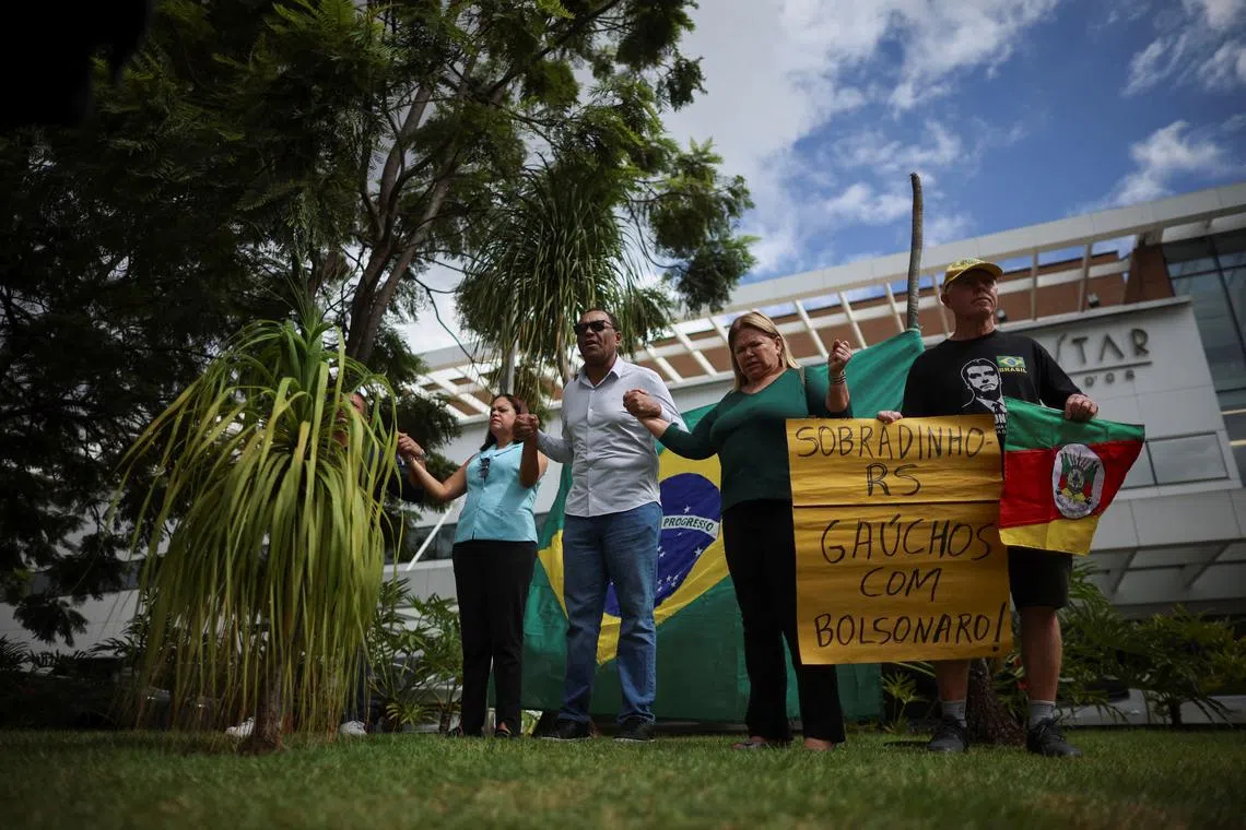 FILE PHOTO: Supporters of Brazil's former President Jair Bolsonaro pray for him in front of DF Star Hospital, where Bolsonaro underwent a surgery in Brasilia, Brazil April 14, 2025. REUTERS/Adriano Machado/File Photo