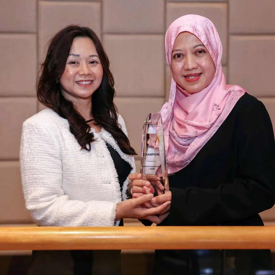 UOB's Tiong Bahru deputy branch manager Jessica Lee (left) and UOB’s Raffles Place branch service manager Azlinah Amin holding the champion award on Oct 7.
