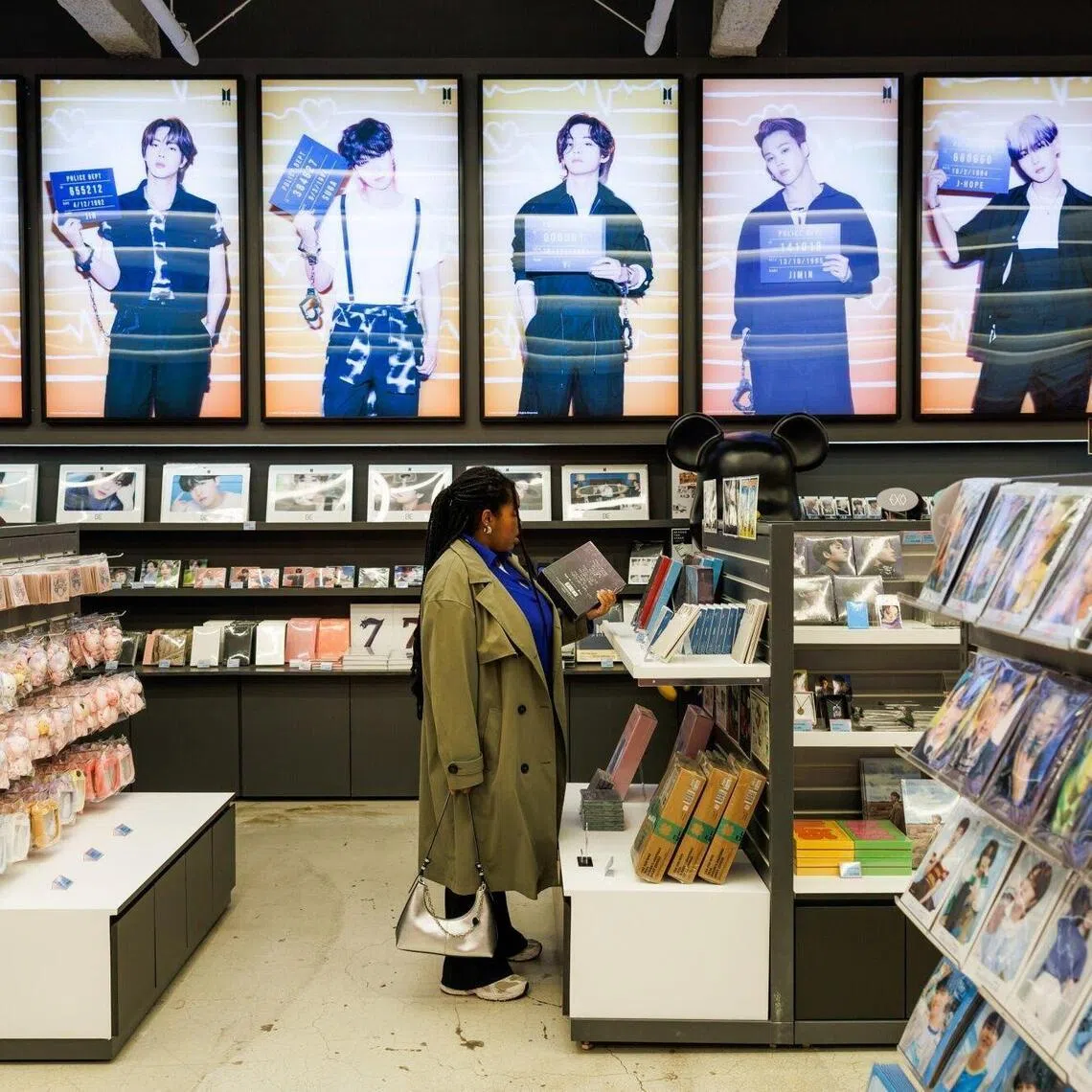 Customers browse K-pop band BTS merchandise at a souvenir store in Seoul, South Korea, on Wednesday, March 18, 2026. After a near four-year hiatus, K-pop megastars BTS are back with a new album, a live-stream deal with Netflix Inc. — and a world tour that could rival Taylor Swift’s record-breaking $2 billion Eras Tour in earnings. Photographer: SeongJoon Cho/Bloomberg