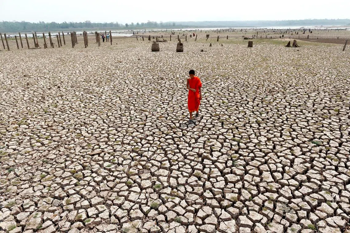 epa05210488 A photo made available on 14 March 2016 shows a Thai Buddhist novice monk walking on drought parched land at a ruined village which has been underwater after the Mae Chang reservoir dried up in Lampang province, northern Thailand, 12 March 2016. The ruined village including ancient temple had been underwater for 34 years since the Mae Chang reservoir was built in 1982, the area has now re-emerged after water in the reservoir dried up caused by the severe drought. Thailand is facing the worst drought in decades hardest hit by El Nino phenomenon combined with seasonal hot weather. EPA/RUNGROJ YONGRIT
caption to come
