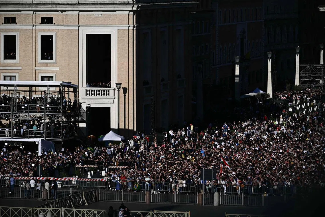 Faithful react near St Peter's Square as white smoke rose from the chimney of the Sistine Chapel signalling that cardinals elected a new pope during their secret conclave, in The Vatican, on May 8, 2025. (Photo by Filippo MONTEFORTE / AFP)