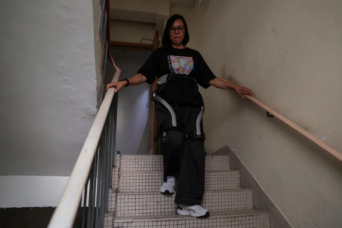 Ms Betty Ho, a resident of Hong Kong's Wang Fuk Court, tries on a robotic exoskeleton ahead of her first visit home to retrieve belongings after a deadly fire last year.
