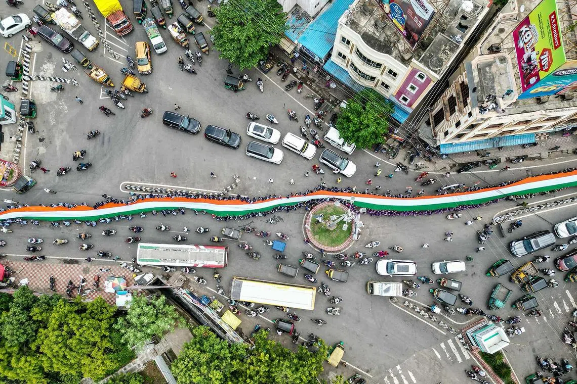An aerial view of school students carrying a large Indian national flag during the 'Har Ghar Tiranga' campaign on the eve of the country's Independence Day celebrations in Vijayawada on Aug 14, 2024.