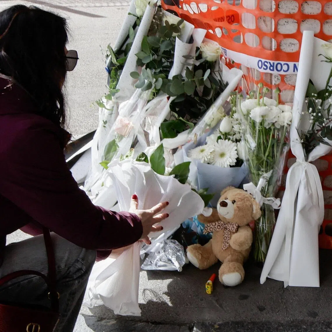 A woman leaves flowers to pay tribute to a toddler who died after a heart transplant, outside Monaldi Hospital in Naples, Italy, February 21, 2026. REUTERS/Salvatore La Porta