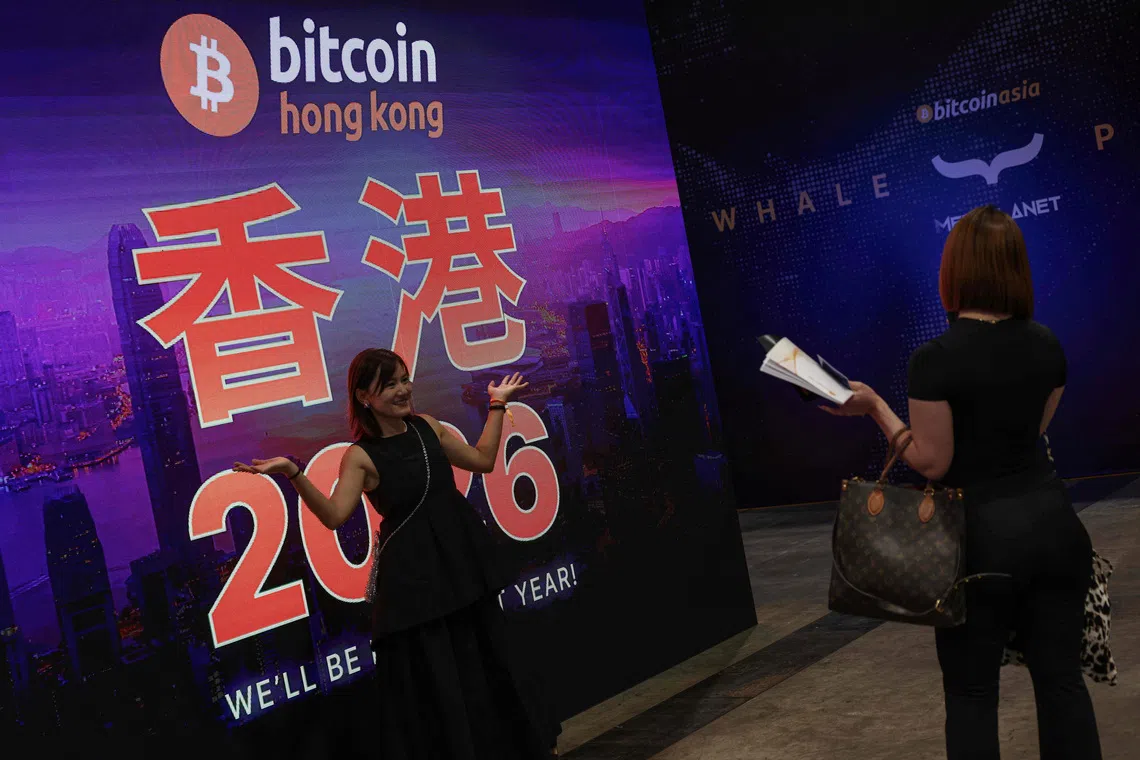 A visitor poses for photos during the Bitcoin Asia conference in Hong Kong on Aug 28.
