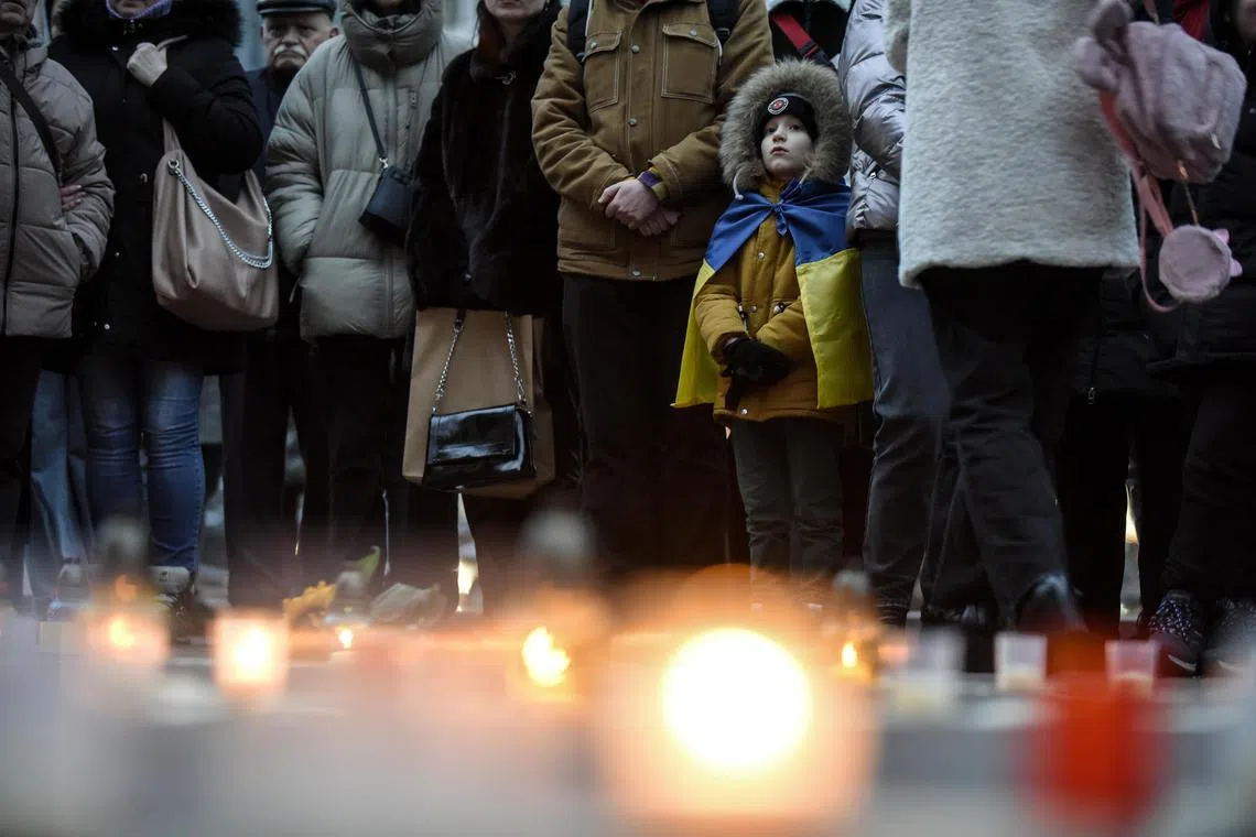 People attend an event in Kyiv to mark the first anniversary of a drama theatre in Mariupol, Ukraine, being bombed by Russia.