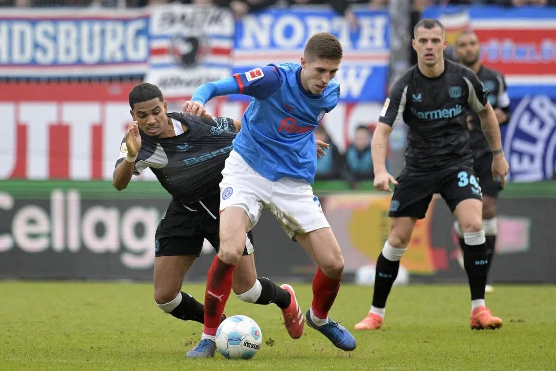 Soccer Football - Bundesliga - Holstein Kiel v Bayer Leverkusen - Holstein-Stadion, Kiel, Germany - February 22, 2025 Holstein Kiel's Marko Ivezic in action with Bayer Leverkusen's Amine Adli REUTERS/Fabian Bimmer